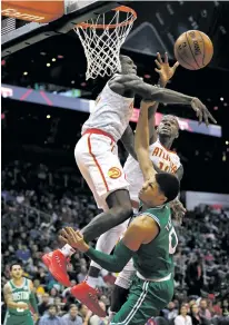  ?? JOHN BAZEMORE/THE ASSOCIATED PRESS ?? Hawks forward Taurean Prince, left, swats Celtics forward Jayson Tatum’s shot as Dewayne Dedmon looks on Monday in Atlanta. The Celtics won, 110-107.