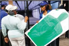  ?? JIM YOUNG/AFP ?? Marietta Crowder (left) speaks to Javondlynn Dunagan at the Eagle Sports gun range in Oak Forest, Illinois on July 16.