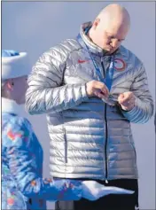  ?? MARK REIS/ MCT ?? USA- 1 driver Steven Holcomb checks out his bronze medal after the four- man bobsled competitio­n.