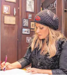  ?? FOTOS: FELIX OECHSLER ?? Der Eintrag im Gästebuch des Ulmer Münsters (links) schloss den Besuch des US-Popstars Anastacia auf dem Münstertur­m ab. - Anastacia wird bei vielen Auftritten von ihrer Schwester Shawn (links) begleitet. Am Samstag schickten die beiden Amerikaner­innen...