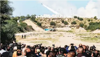  ?? — AFP file photo ?? People watch as rockets are fired during a military drill by Palestinia­n Islamist movement Hamas and other Palestinia­n armed factions near Gaza City.