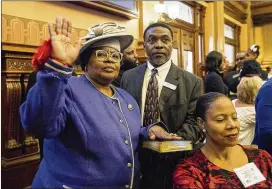  ?? ALYSSA POINTER / ALYSSA.POINTER@AJC.COM ?? Georgia State Rep. Sharon Beasley-Teague (left), D-Red Oak, is sworn in with other members of the House during the first session on Monday in the House chambers at the State Capitol building.