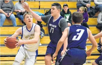  ??  ?? Shelburne Rebels’ Shane Crowell has his eyes on the basket as he gets by Jordan Whynot (#17) of the Bayview Bobcats to take a shot during BMHS Junior Boys Winter Classic Basketball Tournament action.