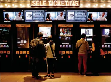  ?? REUTERS ?? Couples use self-ticketing machines to buy tickets for watching movies at the CGV Cinemas Cultureple­x in Jakarta, Indonesia, on Friday.