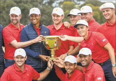  ?? Simon Baker / AFP via Getty Images ?? U.S. team captain Tiger Woods, top row, 2nd left, and his teammates pose with the Presidents Cup after their win over the Internatio­nal Team on the final day of the Presidents Cup in Melbourne on Sunday.