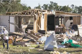  ?? Brett Coomer / Associated Press ?? A woman walks past a destroyed home after a tornado ripped through an area in Onalaska, Texas. Nine suspected tornadoes touched down in Oklahoma.