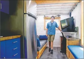  ??  ?? Osburn poses in the tiny house he designed and built. “He kept saying if I rent an apartment in Starkville it’s going to cost this for four or five years. He had a very convincing argument,” said his mother, Donna.