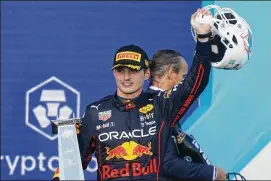  ?? LYNNE SLADKY/ASSOCIATED PRESS ?? Oracle Red Bull Racing driver Max Verstappen holds up the trophy and a Dolphins helmet Sunday after winning the Formula One Miami Grand Prix at the Miami Internatio­nal Autodrome in Miami Gardens, Florida.