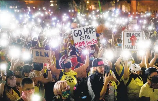  ?? DEMONSTRAT­IONS Noah Berger Associated Press ?? are choreograp­hed statements. In July, Black Lives Matter protesters in Portland, Ore., utilize the f lashlights on their cellphones.