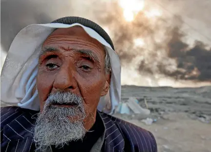  ?? PHOTO: REUTERS ?? A man returns to his village after it was liberated from Islamic State militants, south of Mosul in Qayyara, Iraq. The fumes in the background are from oil wells that were set ablaze by Islamic State militants.