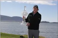  ?? AP PHOTO BY ERIC RISBERG ?? Phil Mickelson poses with his trophy on the 18th green of the Pebble Beach Golf Links after winning the AT&amp;T Pebble Beach Pro-am golf tournament Monday, Feb. 11, in Pebble Beach, Calif.