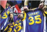  ??  ?? Warriors fans hold out their Durant jerseys, hoping they’ll get his autograph.