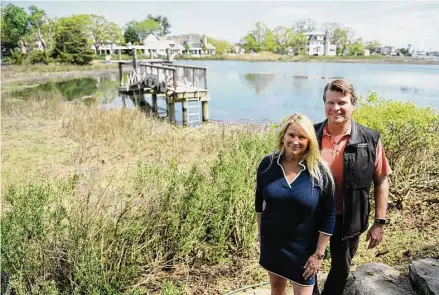  ?? Tyler Sizemore/Hearst Connecticu­t Media ?? Marti Marache, left, and Mark Marache pose by the dock on the shore of their property in the Riverside section of Greenwich on May 8.