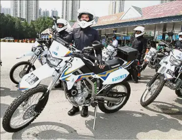  ??  ?? Roadworthy team: Police officers showing their new motorcycle­s for patrol duties at the launch of the 12th ‘Op Selamat’ at the Jalan Duta toll plaza.