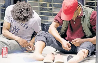  ?? ?? STICKING POINT: Two men use syringes outside a store on West 35th Street, near Eighth Avenue, on Sunday.