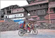  ?? BERNAT ARMANGUE / AP ?? A Nepali cycle rickshaw pedals past buildings at Basantapur Durbar Square that were damaged in a 2015 earthquake in Kathmandu, Nepal.