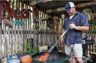  ?? Marvin Pfeiffer / Staff photograph­er ?? Chuck Blount lights a full configurat­ion of charcoal briquettes, one of four setups he recommends.