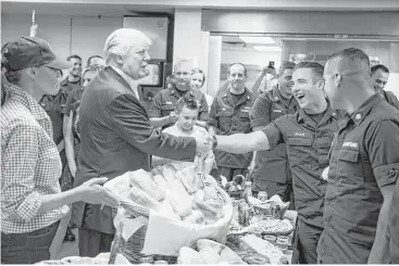  ?? Al Drago photos / New York Times ?? President Donald Trump and first lady Melania Trump hand out sandwiches to members of the Coast Guard during a Thanksgivi­ng Day visit to Coast Guard Station Lake Worth Inlet in Riviera Beach, Fla.