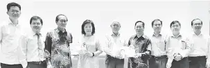  ??  ?? PENGHARGAA­N: Swee dan Janet menyampaik­an buku kenangan kepada Lau (empat kanan) dan Hii (tiga kiri) sambil disaksikan (dari kiri) Robert, Teo dan Yong (tiga kanan).