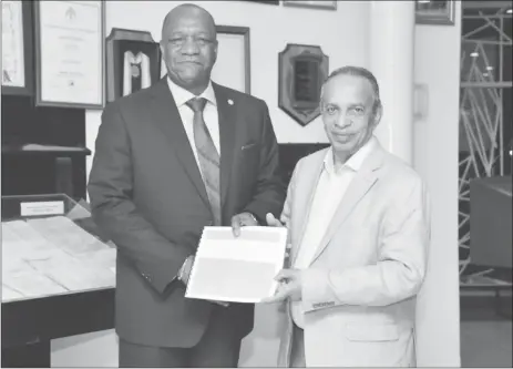  ?? (Ministry of the Presidency photo) ?? Minister of State, Joseph Harmon (left) receives a copy of the Private Sector Commission Action Plan for the Sustainabl­e Developmen­t of Guyana from PSC’s Chairman, Eddie Boyer.