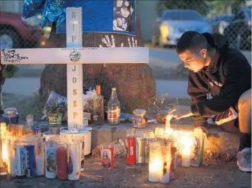  ?? Gina Ferazzi Los Angeles Times ?? KYLE RODRIGUEZ, 19, lights a candle for his brother, who was shot and killed last year in San Bernardino. The city struggles with violent crime and limited resources, and has looked to the federal government for help.