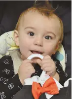  ??  ?? NO DISGUISING HAPPINESS: Eightmonth-old Owen Fish, above, holds a Dracula costume at Interfaith Social Services, below.