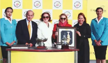  ?? Courtesy: DDF ?? Maureen Haggas, wife of trainer William Haggas, receives the Dubai Duty Free Cup Trophy from Colm McLoughlin, Sinead Al Sibai and Jasmin Micoyco. Haggas sent out Mankib, owned by Shaikh Hamdan, to win the race during the DDF Internatio­nal Weekend at Newbury.