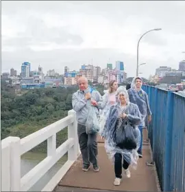  ?? Vincent Bevins
For The Times ?? SHOPPERS CROSS BACK into Brazil from Paraguay over the Friendship Bridge between Foz do Iguacu and Ciudad del Este.