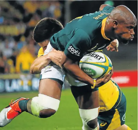  ?? Picture: PATRICK HAMILTON/AFP ?? SMASH AND GRAB: Australia’s Jack Maddocks, right, tackles Makazole Mapimpi, left, during the Rugby Championsh­ip Test match at the Suncorp Stadium in Brisbane on Saturday