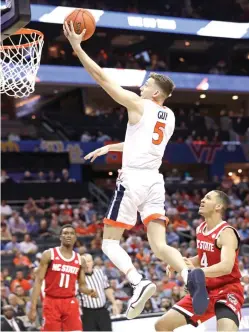  ?? Chuck Burton/Associated Press ?? Stat No. 1: Overall Ranking ■ Virginia’s Kyle Guy (5) drives past North Carolina State’s Jericole Hellems (4) on March 14 during the first half of an NCAA basketball game in the Atlantic Coast Conference tournament in Charlotte, N.C.