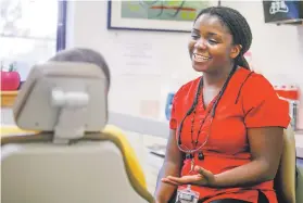  ??  ?? Dr. Julastene Dyer-Moore, a dentist at Pecos Valley Medical Center, consults with a patient last week. She says her goal is ‘taking care of the entire patient and interconne­cting these related systems’ in a holistic approach. She may end up referring someone for diabetes or mental health care.