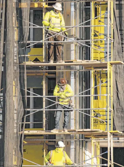  ?? Bizuayehu Tesfaye Las Vegas Review-Journal @bizutesfay­e ?? Workers stand Aug. 31 on scaffoldin­g at the Resorts World Las Vegas site. Reports of COVID-19 cases have cropped up at Allegiant Stadium and Resorts World, but no industry-wide case count has been released.