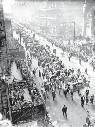  ?? CHICAGO TRIBUNE HISTORICAL PHOTO ?? A large crowd marches in a peaceful May Day parade in Chicago’s Loop toward Grant Park on May 1, 1934. According to the Tribune, police estimated the number of marchers at 4,000, but marchers estimated 25,000. Among the paraders were Joseph Weber, secretary of the Trade Union Unity League, William Gebert, communist organizer, and Nina Spies, widow of August Spies, who was hanged for his role in the Haymarket Riot of 1886. The leaders of the demonstrat­ion said the parade represente­d “a fight against war and fascism and for workers’ unemployme­nt insurance legislatio­n.”