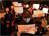  ?? AP ?? Protesters hold up blank papers and chant slogans in Beijing, Sunday. Protesters angered by strict antivirus measures called for China’s powerful leader to resign.