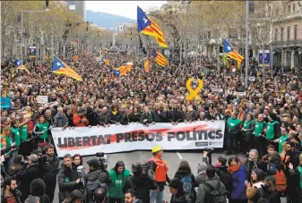  ?? Lluis Gene / AFP / Getty Images ?? Protesters hold a banner reading “Freedom to political prisoners” during a demonstrat­ion in Barcelona after Catalonia’s former president was arrested in Germany on Sunday.