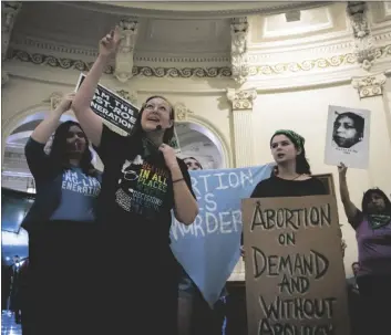  ?? SARA DIGGINS/AUSTIN AMERICAN-STATESMAN VIA AP ?? Sarah Bentley (second from left) leads songs at an Internatio­nal Women’s Day Sit-In for Abortion Rights in the Texas State Capitol Rotunda, on March 8 in Austin, Texas.