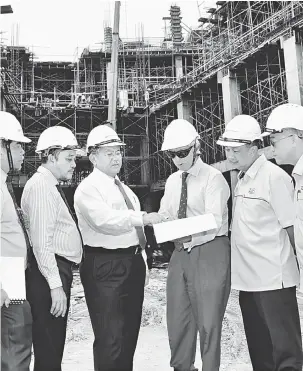  ??  ?? TINJAU: Morshidi (tengah) melawat tapak projek pembinaan Kampus Muzium Sarawak bersama Richard (tiga kanan), Aziz (tiga kiri) dan Ipoi (kiri).