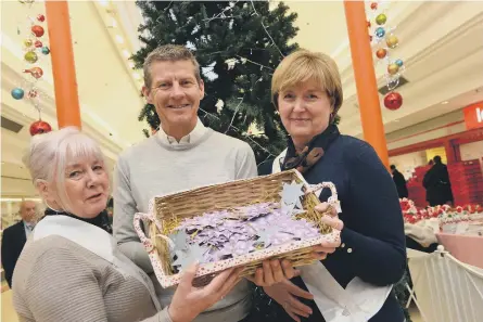  ??  ?? Steve Cram at the St Benedict’s Hospice charity tree with volunteers Annette Murray, left, and Judith Stout with charity baubles.