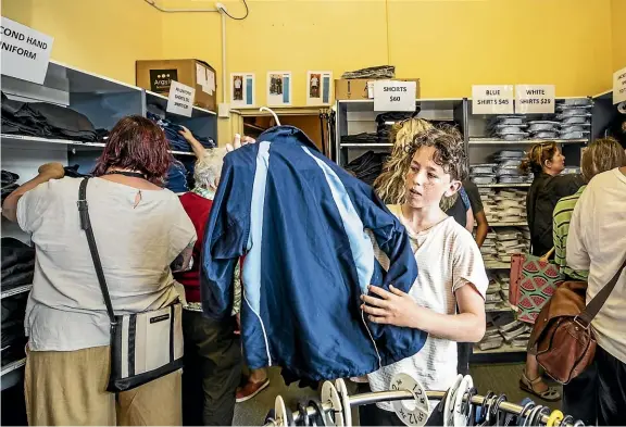  ?? BRADEN FASTIER/STUFF ?? Enda Doherty, 13, looks for a school jacket at the Nelson College uniform shop. It was busy in the lead up to the start of school.