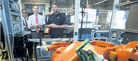  ?? TODD KOROL/THE CANADIAN PRESS ?? Finance Minister Bill Morneau, centre, operates a robot with student Spencer Pelzer, right, while Calgary Mayor Naheed Nenshi looks on during a tour of the robotics lab last week at the Southern Alberta Institute of Technology in Calgary.