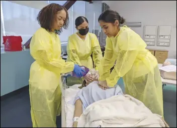  ?? JULIE DRAKE/VALLEY PRESS ?? Eastside High School Biomedical Science Academy students Abigail Morales (left), Amya Bardalez and Stephanie Galind participat­e. this summer, in the nursing simulation lab at Antelope Valley College as part of a summer pilot internship program.