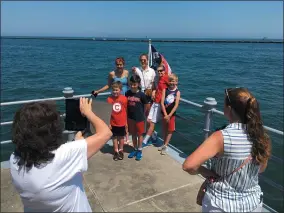  ??  ?? Natalie Mantini points as her grandmothe­r, Gloria Mantini, lines up a group photo.