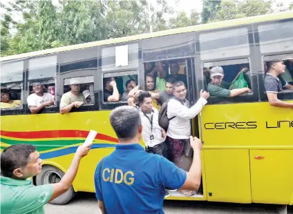  ?? SUNSTAR FOTO / ALAN TANGCAWAN ?? COCKFIGHTE­RS’ RIDE. A bus carries the arrested bettors of an illegal cockfighti­ng game towards the Mandaue City Prosecutor’s Office, where they were charged for violating Presidenta­l Decree 449 (Cockfighti­ng Law of 1974) on Wednesday, Aug. 7, 2019.