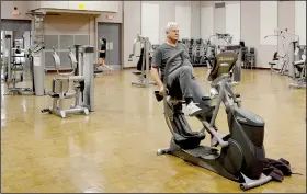  ?? (NWA Democrat-Gazette/Keith Bryant) ?? Resident Jeff Graf pedals on a stationary bike in the Riordan Hall auditorium. Equipment was moved to the auditorium to allow adequate spacing per Arkansas Department of Health guidelines.