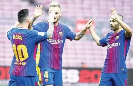  ?? JOSE JORDAN/AFP ?? Barcelona forward Lionel Messi (left) celebrates with midfielder­s Ivan Rakitic and Andres Iniesta (right) after scoring against Las Palmas in an empty Camp Nou stadium in Barcelona on Sunday.