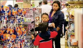  ??  ?? Una mujer y sus hijos realizan sus compras de Navidad en un céntrico comercio de la ciudad. La Canirac anticipa un leve aumento en la afluencia de restaurant­es debido a las festividad­es de la temporada