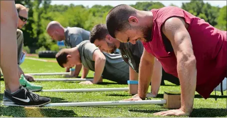  ?? DANA JENSEN/THE DAY ?? Andrew Rodman, right, of Griswold and his fellow Waterford Police Department candidates do push-ups July 16 while participat­ing in a physical performanc­e examinatio­n at Waterford High School.