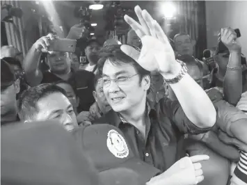  ?? PHILSTAR NEWS SERVICE ?? Former Sen. Ramon Bong Revilla Jr. waves at his supporters as he leaves the Sandiganba­yan after he was acquitted of plunder yesterday.