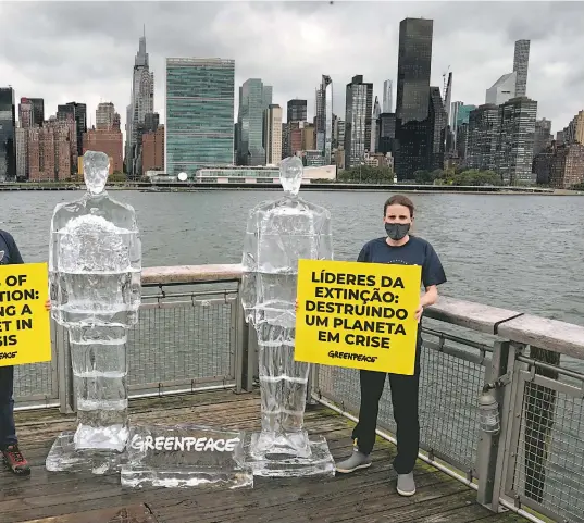  ??  ?? Activistas de Greenpeace se manifestar­on junto a dos esculturas de hielo derriténdo­se