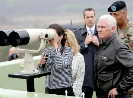  ?? Photo: Bloomberg/Seongjoon Cho ?? US Vice President Mike Pence, right, looks toward North Korea as his daughter uses binoculars from the Demilitari­sed Zone (DMZ) in Paju, South Korea on April 17, 2017.